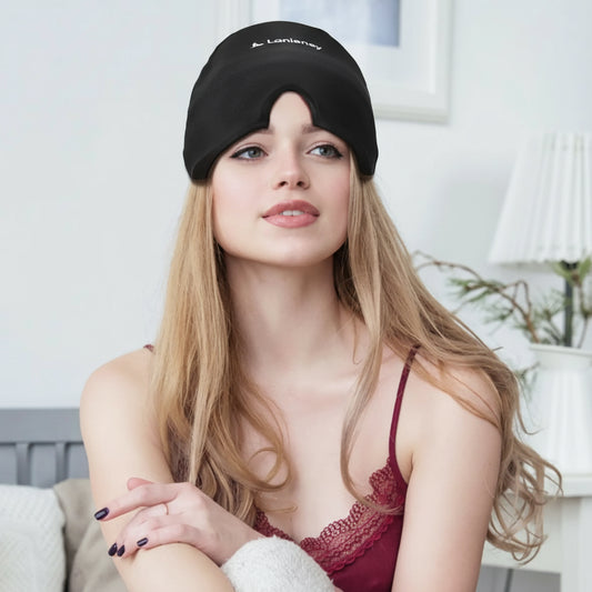 Woman wearing a black headband with a brand logo, sitting indoors.